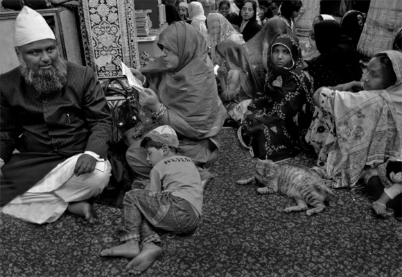 Boy catnapping at a Sufi prayer meeting
