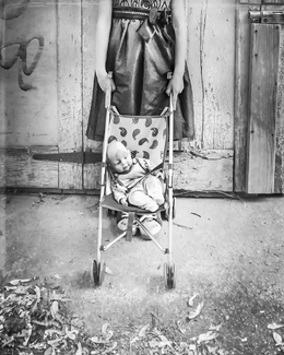 Little girl with her doll stroller Little girl with her doll stroller